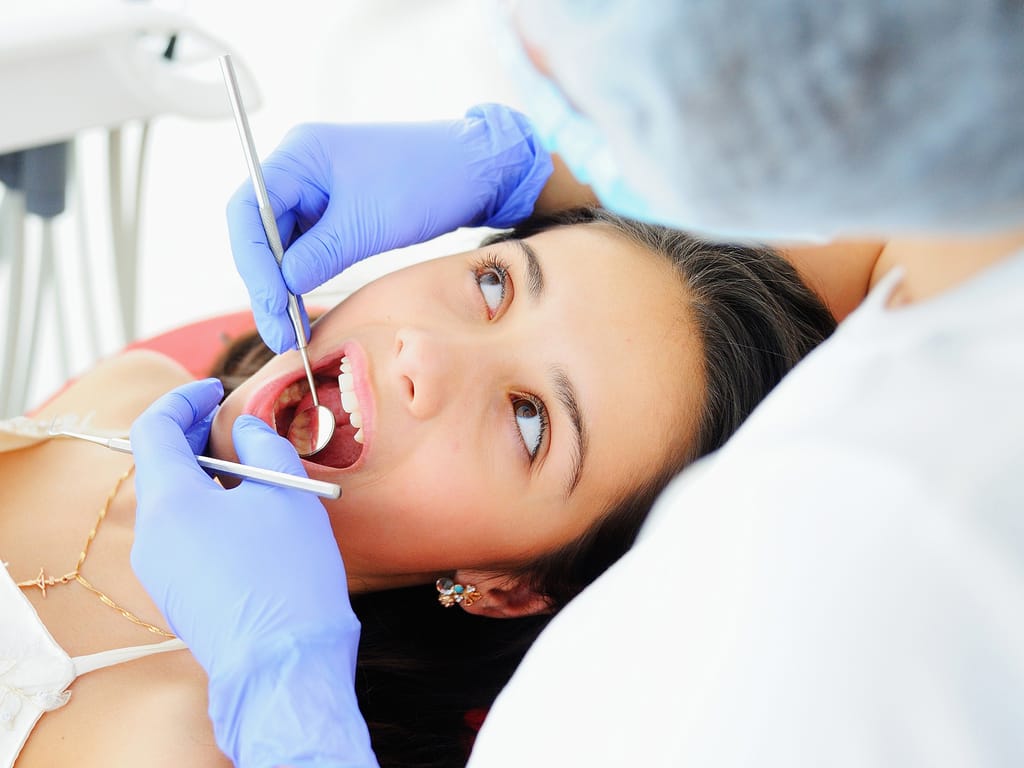 Dentiste examinant une patiente au fauteuil